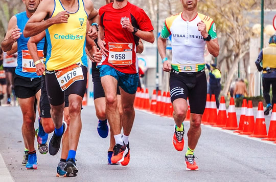 Image of runners at 5k event with street cones in the background